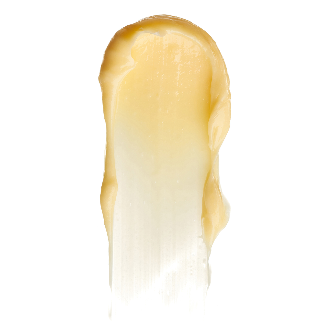 Close-up of a spread yellow cream with a white background.  